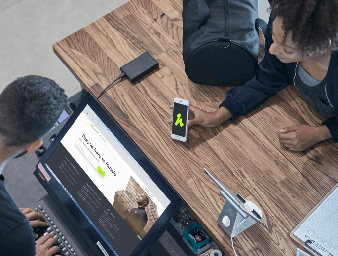 A gym user checks in at the gym reception using the Hussle mobile app